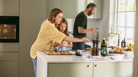 Mand og to børn står i et køkken