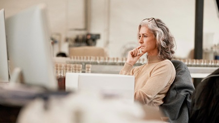Dame sidder og kigger på en skærm