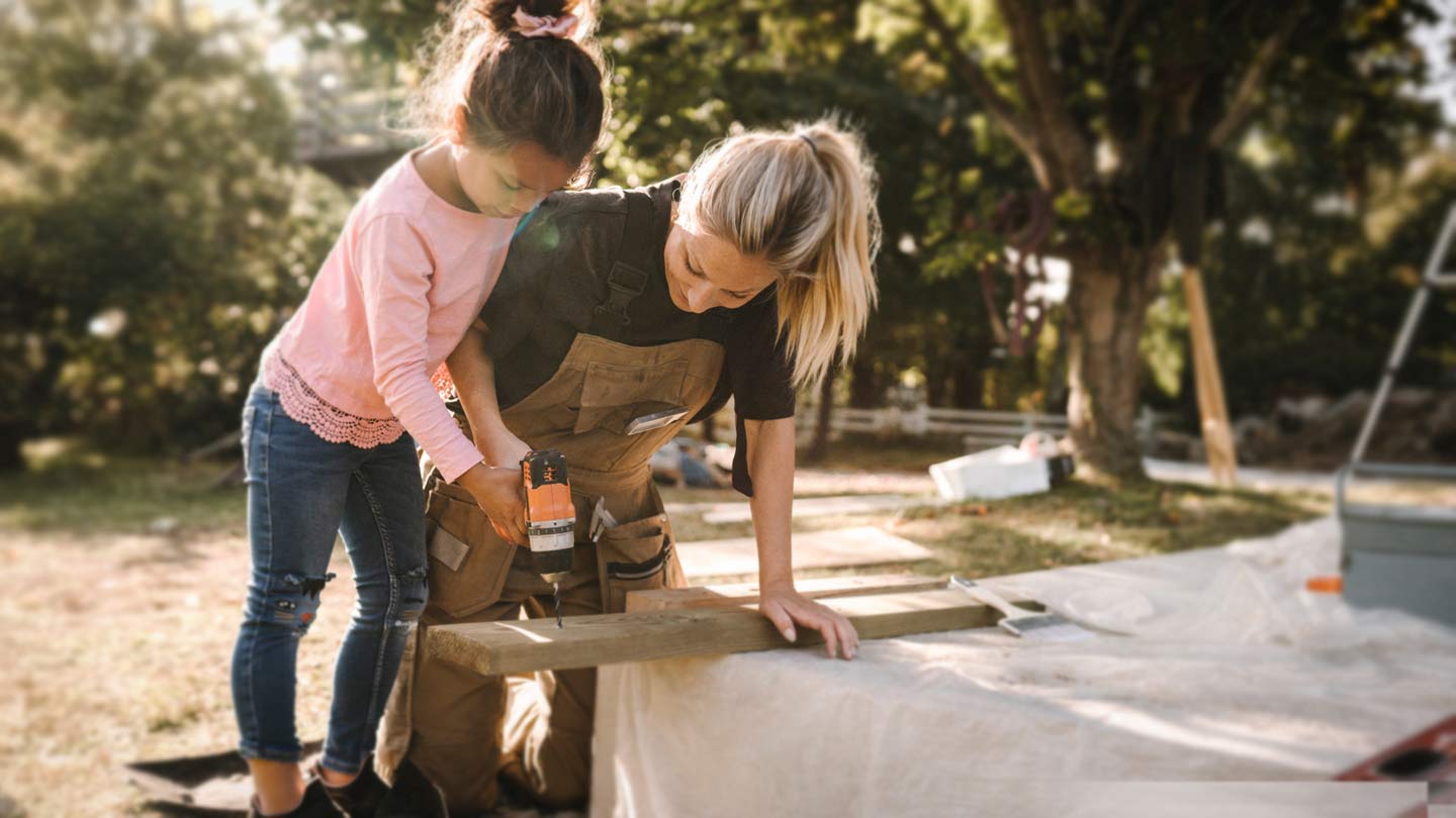 Voksen og barn der borer med en boremaskine