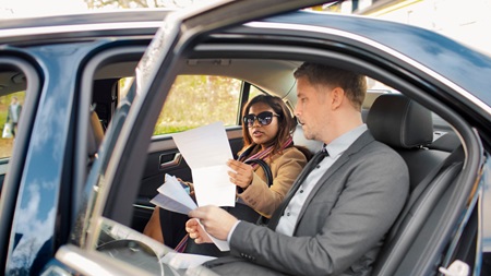 To forretningsfolk diskuterer på bagsædet af firmabil