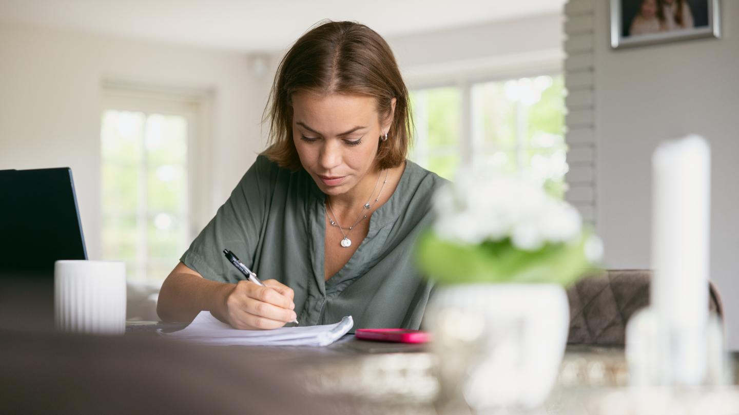 Kvinde skriver på en notesblok