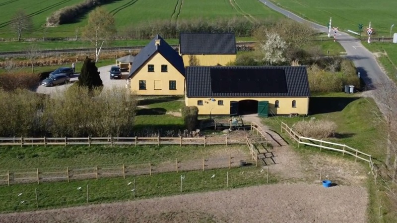 Gård med gul facade og sort tag