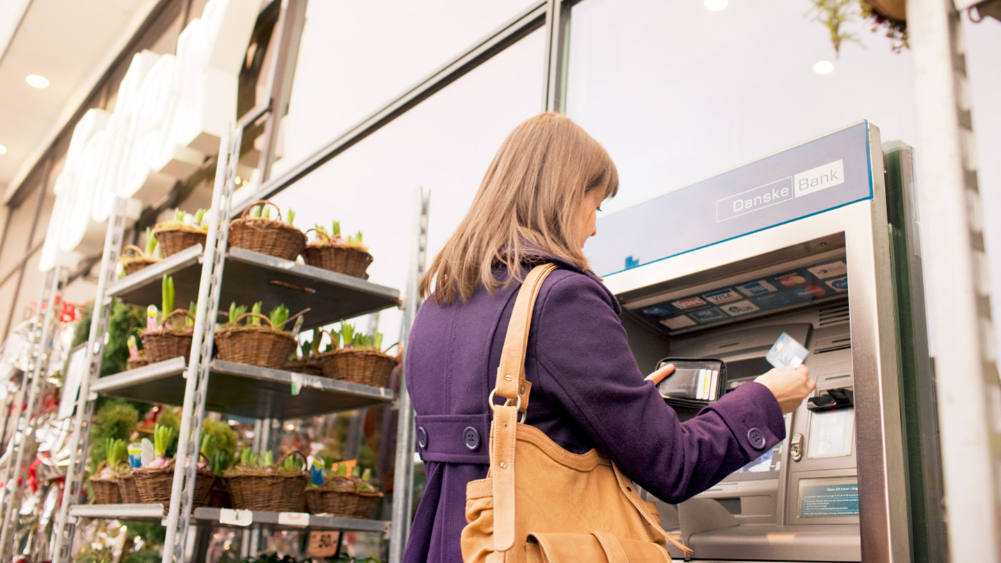 Kvinder hæver kontanter i Danske Bank hæveautomat 