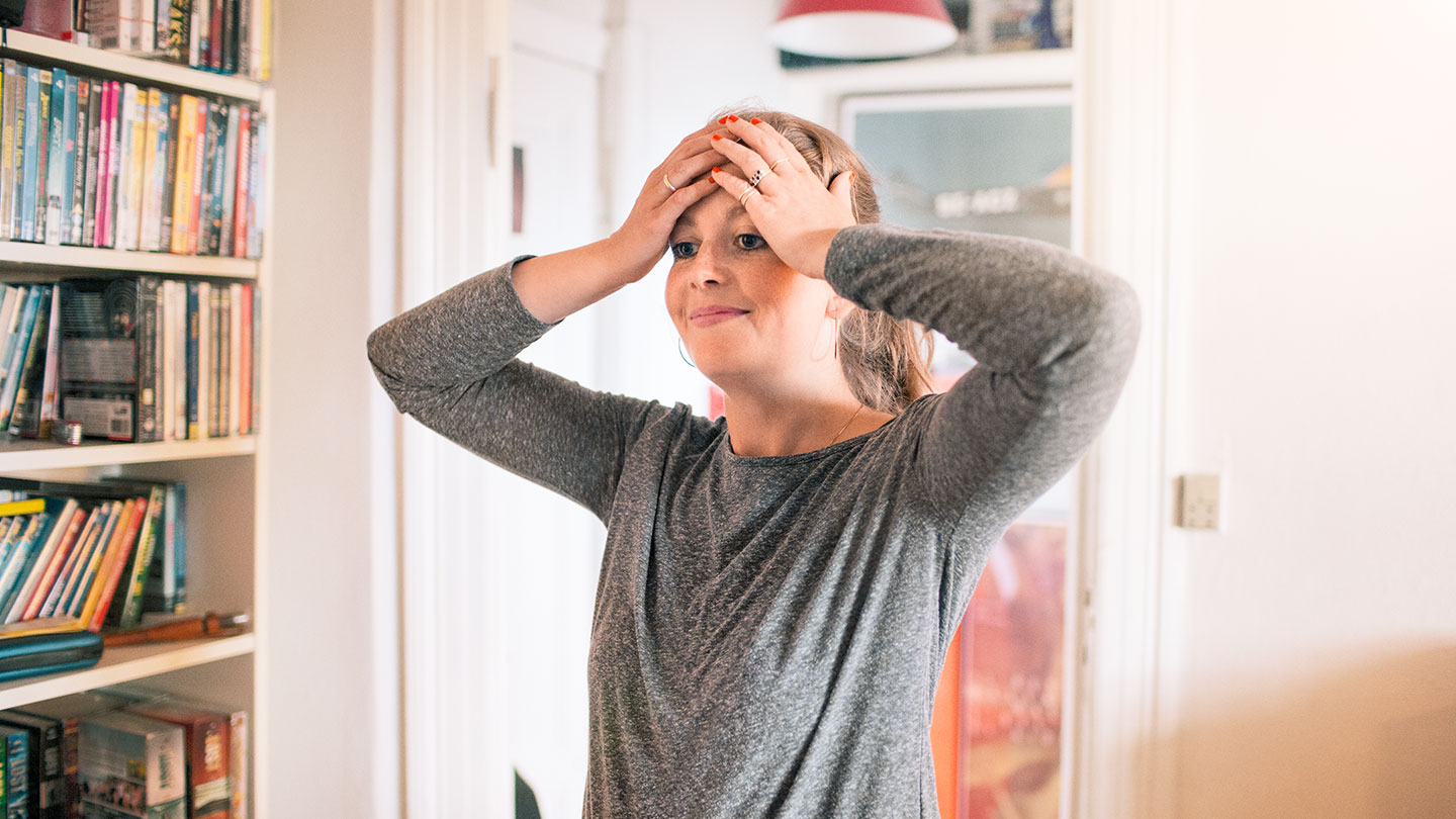 Kvinde tager sig til hovedet