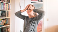 Kvinde tager sig til hovedet